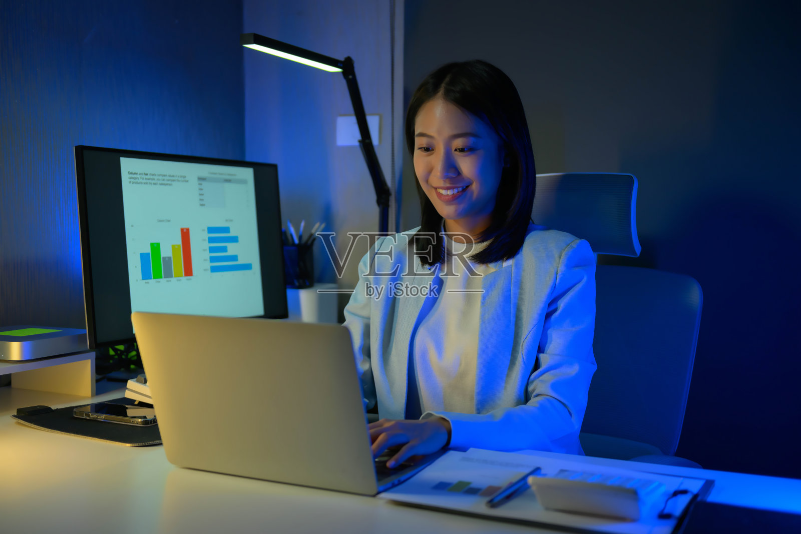 年轻勤劳的女商人晚上在办公室加班的照片。照片摄影图片