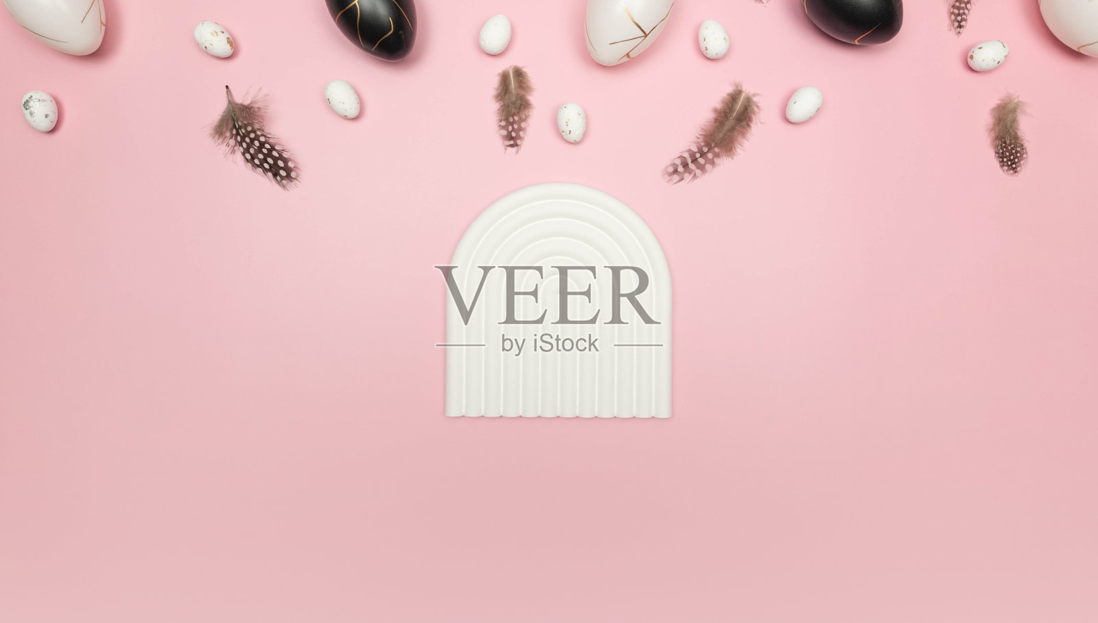 复活节彩蛋俯视图，粉红色背景上的羽毛。白色拱形托盘，产品展示。照片摄影图片