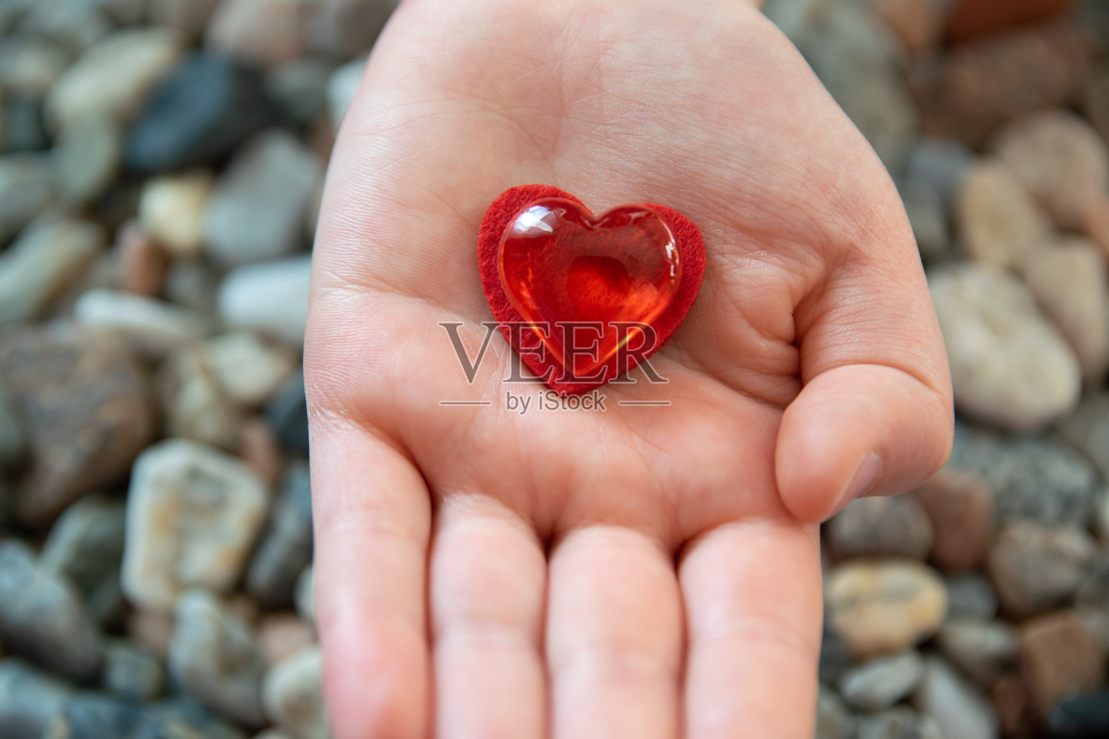 红色的心形在石头的背景上。照片摄影图片