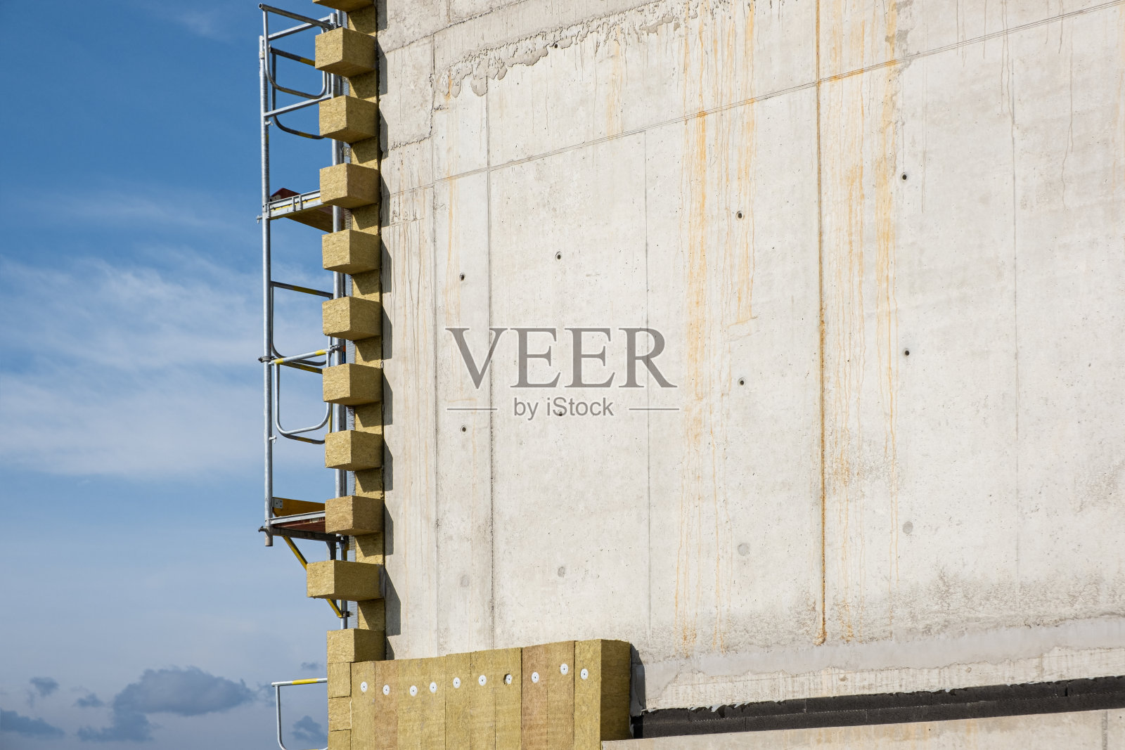 用岩棉垫来给墙隔热，以形成防寒屏障。未完工房屋角落的自然绝缘材料。新住宅建筑节约热能的概念。建筑技术和建筑材料。照片摄影图片