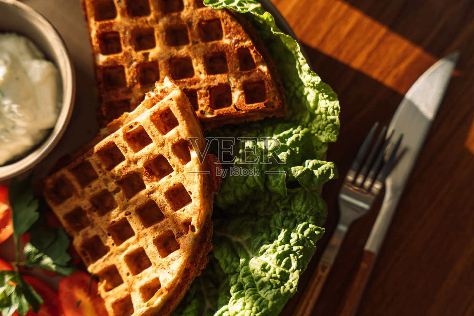 在阳光下的木桌上吃早餐，有华夫饼和茶照片摄影图片