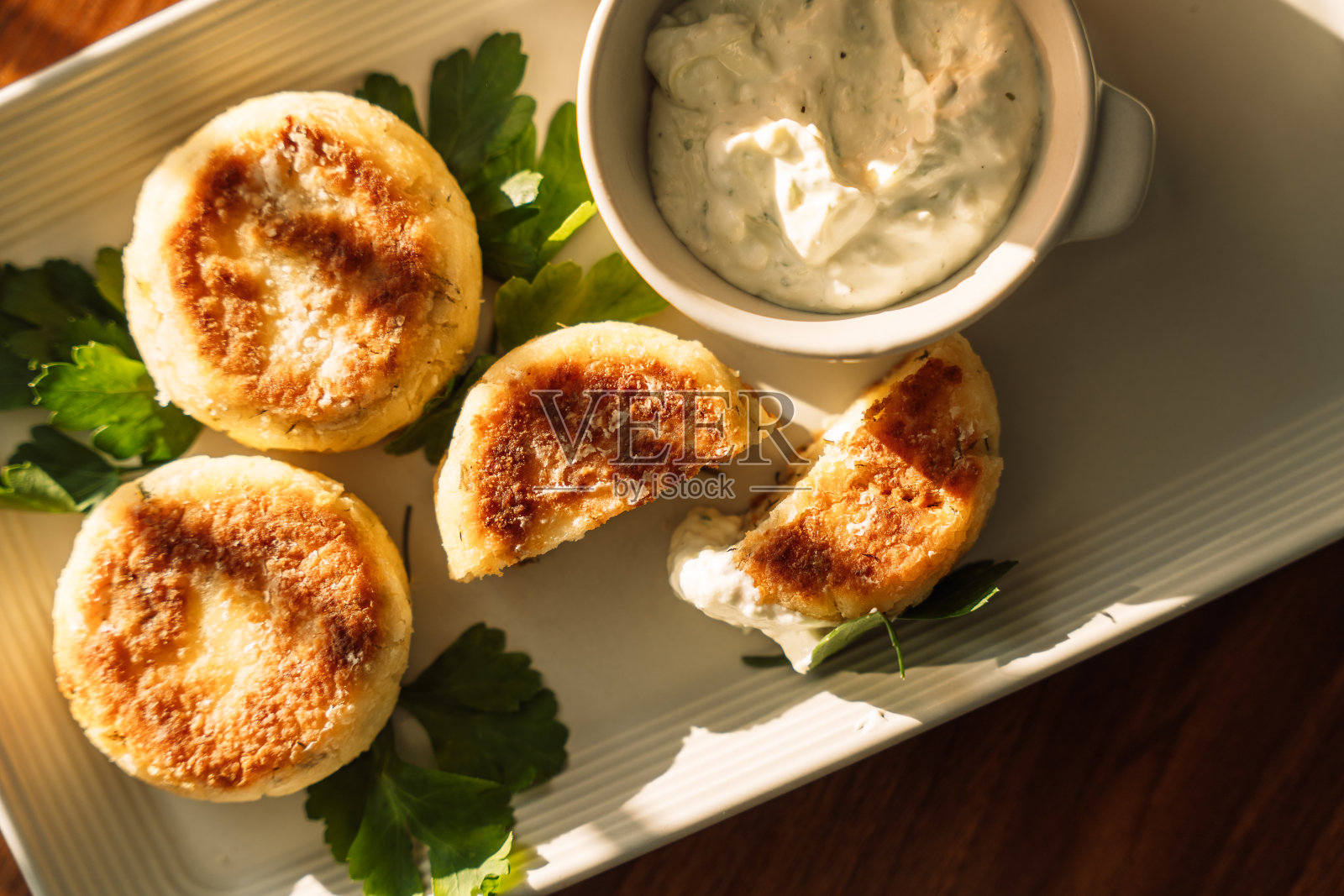 在阳光下，木桌上放着蘸酱的芝士蛋糕照片摄影图片