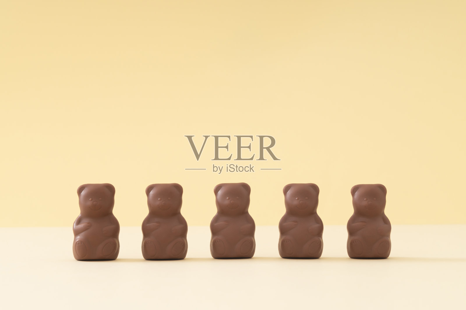 创意安排与巧克力泰迪熊在柔和的奶油色背景。创意甜食概念。美味的巧克力泰迪熊的主意。最小的风格。巧克力的审美。副本的空间。照片摄影图片