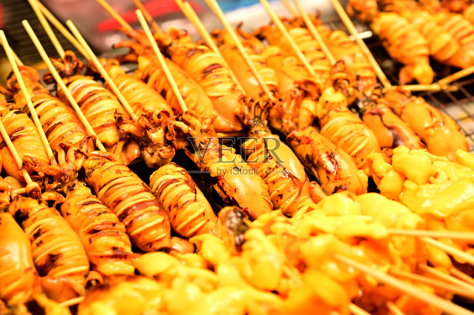 街头小吃市场的炸虫、炸虫、炸蟋蟀、炸海鲜、炸小蟹、烤鸡、烤猪肉、烤鱿鱼、烤虾、烤肠。照片摄影图片
