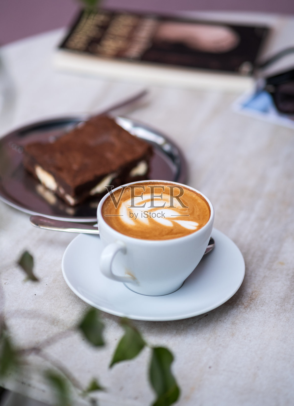 大理石桌上放着一杯拿铁咖啡，还有拉花照片摄影图片