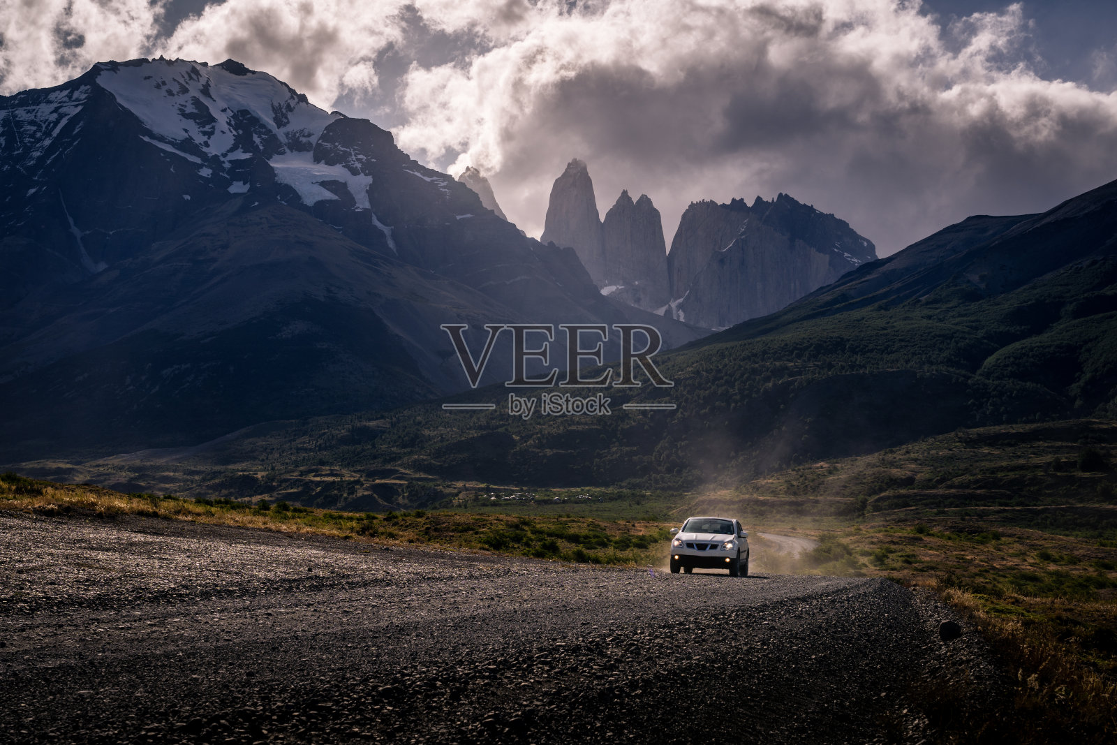 一辆开车前往托里斯德尔潘恩国家公园的汽车，背景是树基塔山和美丽的太阳耀斑(智利巴塔哥尼亚)。照片摄影图片