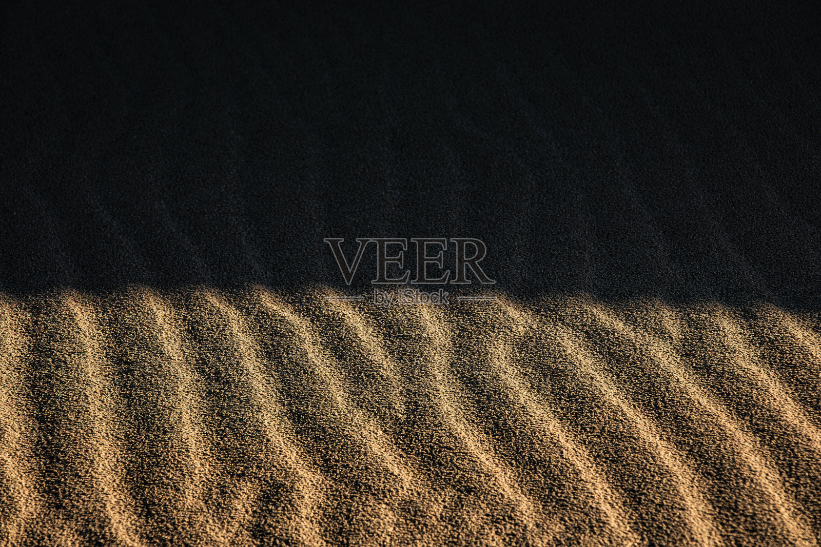 日出的全帧纹理投射阴影在光滑形状的金色沙漠沙丘照片摄影图片