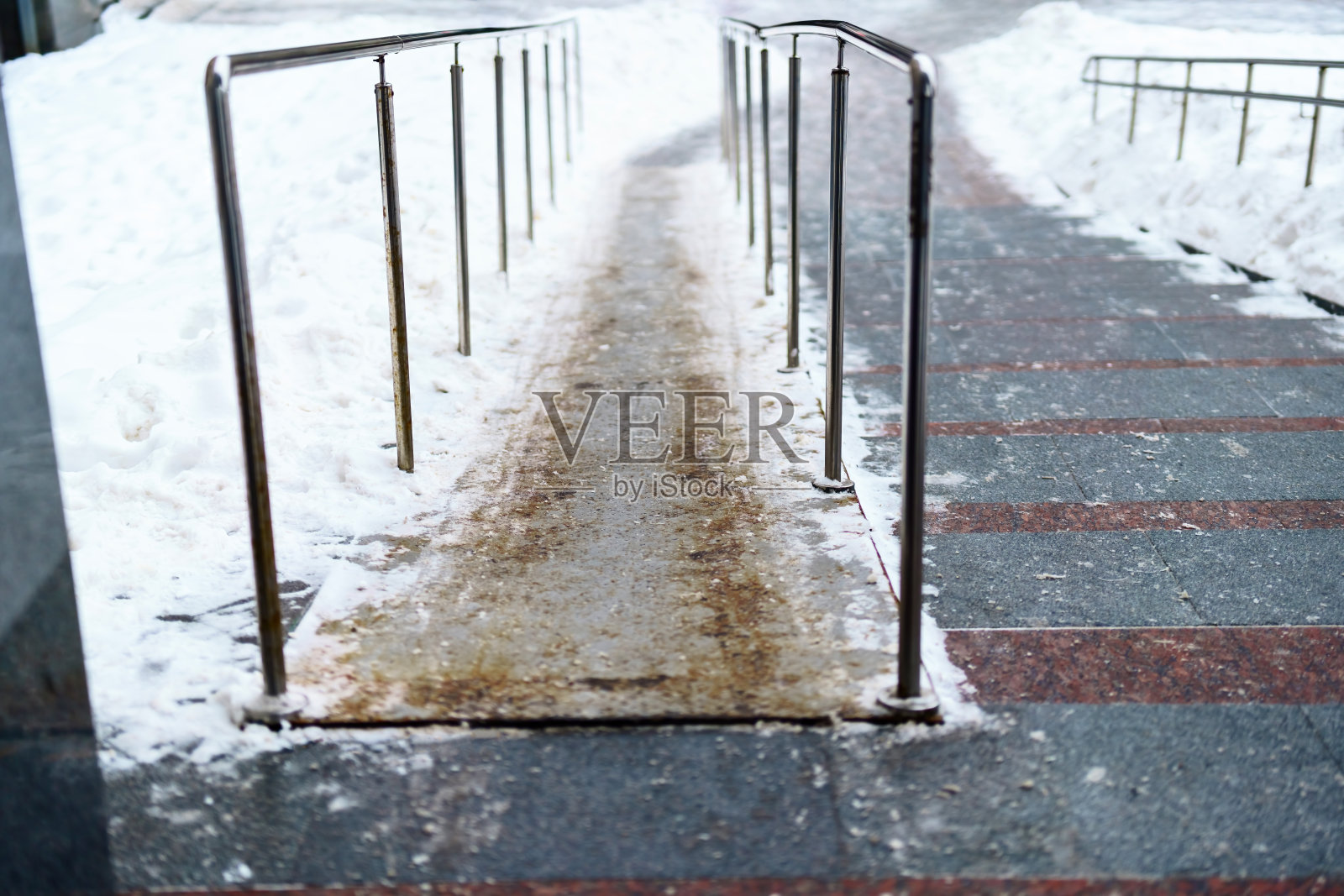 冬季楼梯上供婴儿车使用的金属坡道照片摄影图片