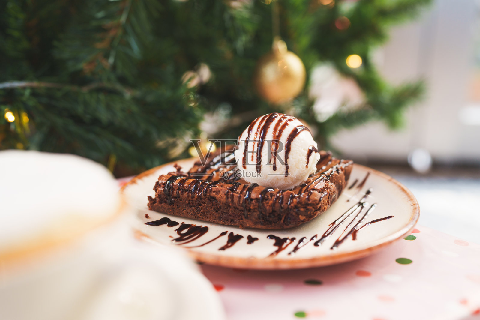 一块上面有香草冰淇淋的布朗尼蛋糕。照片摄影图片