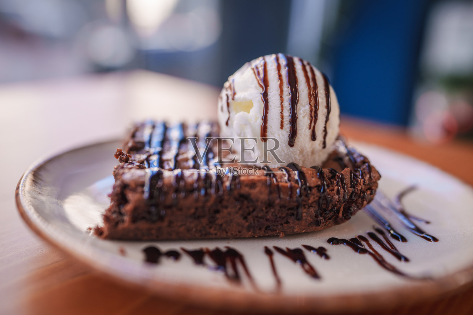 一块上面有香草冰淇淋的布朗尼蛋糕。照片摄影图片