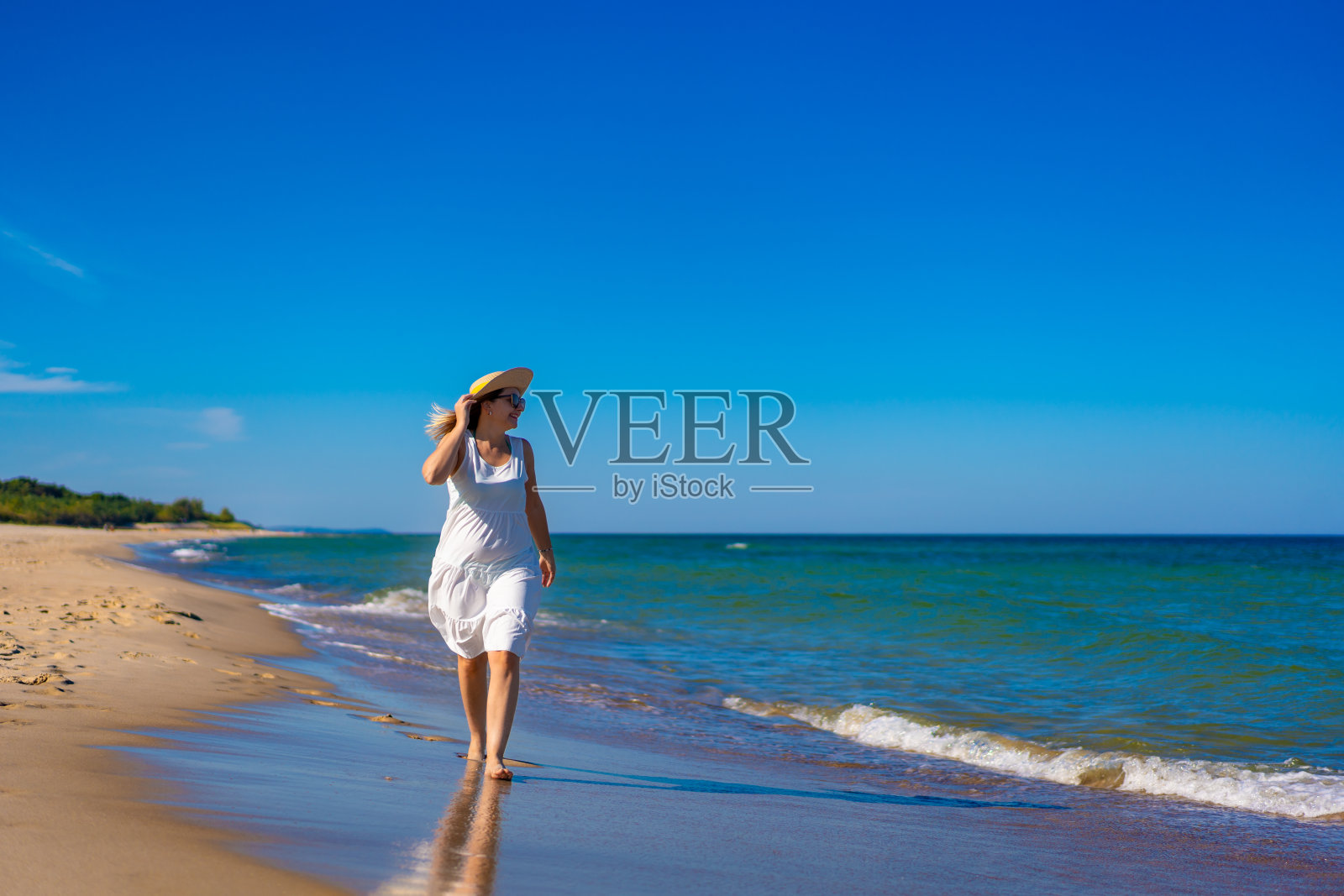 美丽的女人走在沙滩上照片摄影图片