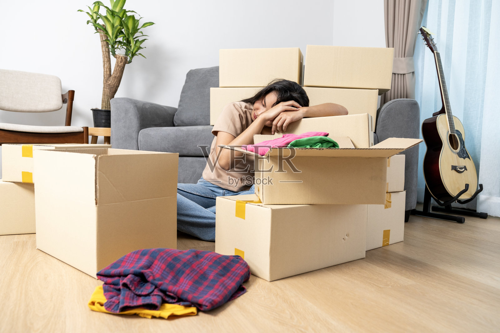 一个疲惫的年轻女子，因为搬东西到新家而筋疲力尽照片摄影图片