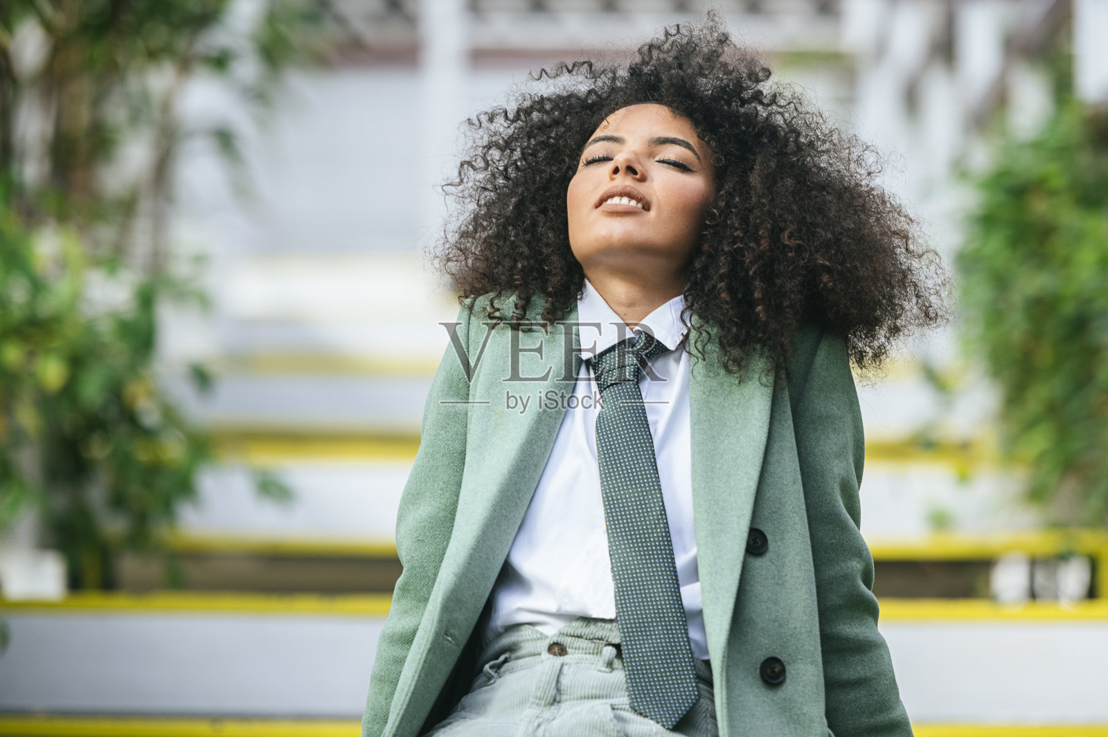 打领带，留着非洲式发型，闭着眼睛的女人照片摄影图片