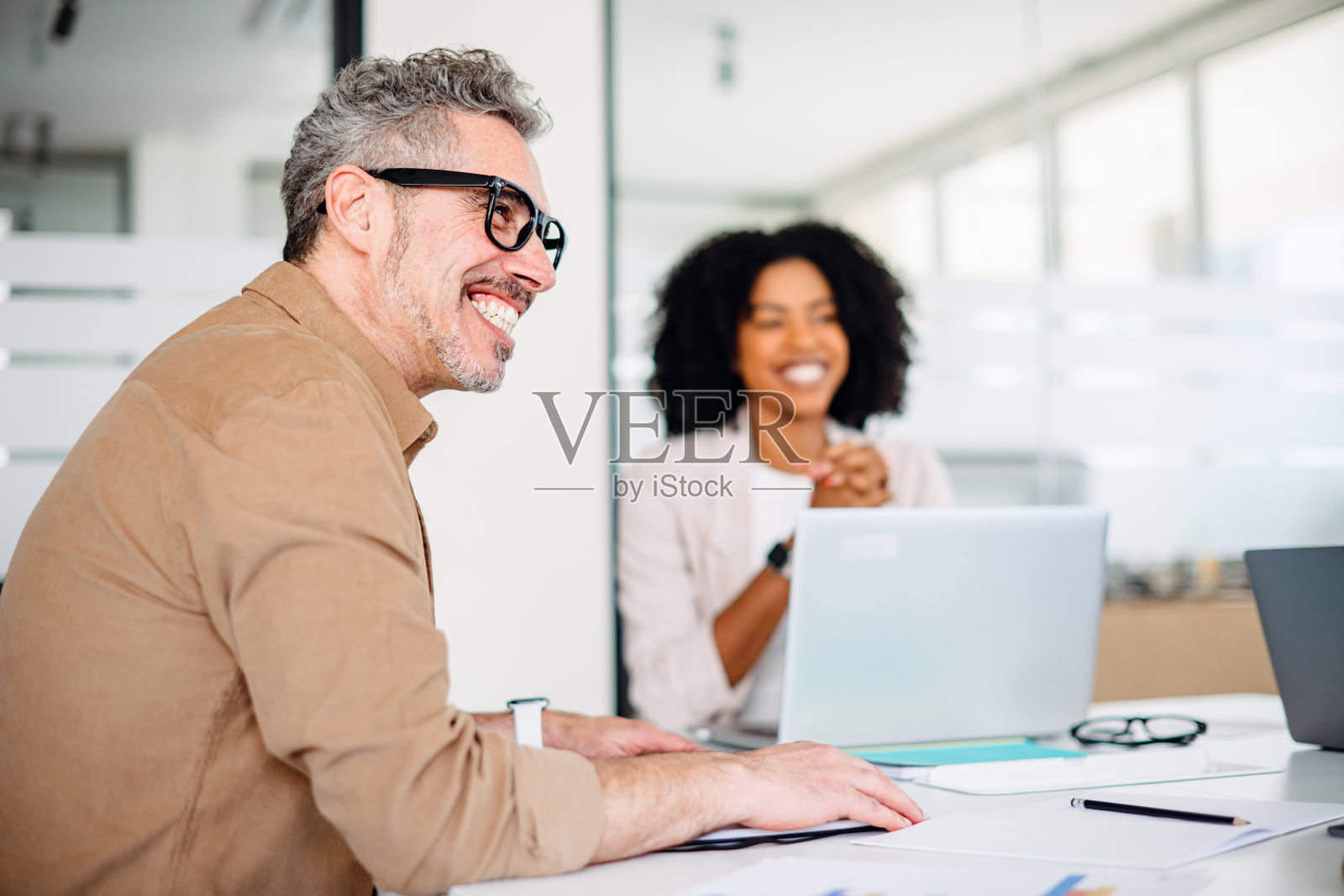 商务会议上，一位男性专业人士开怀大笑照片摄影图片