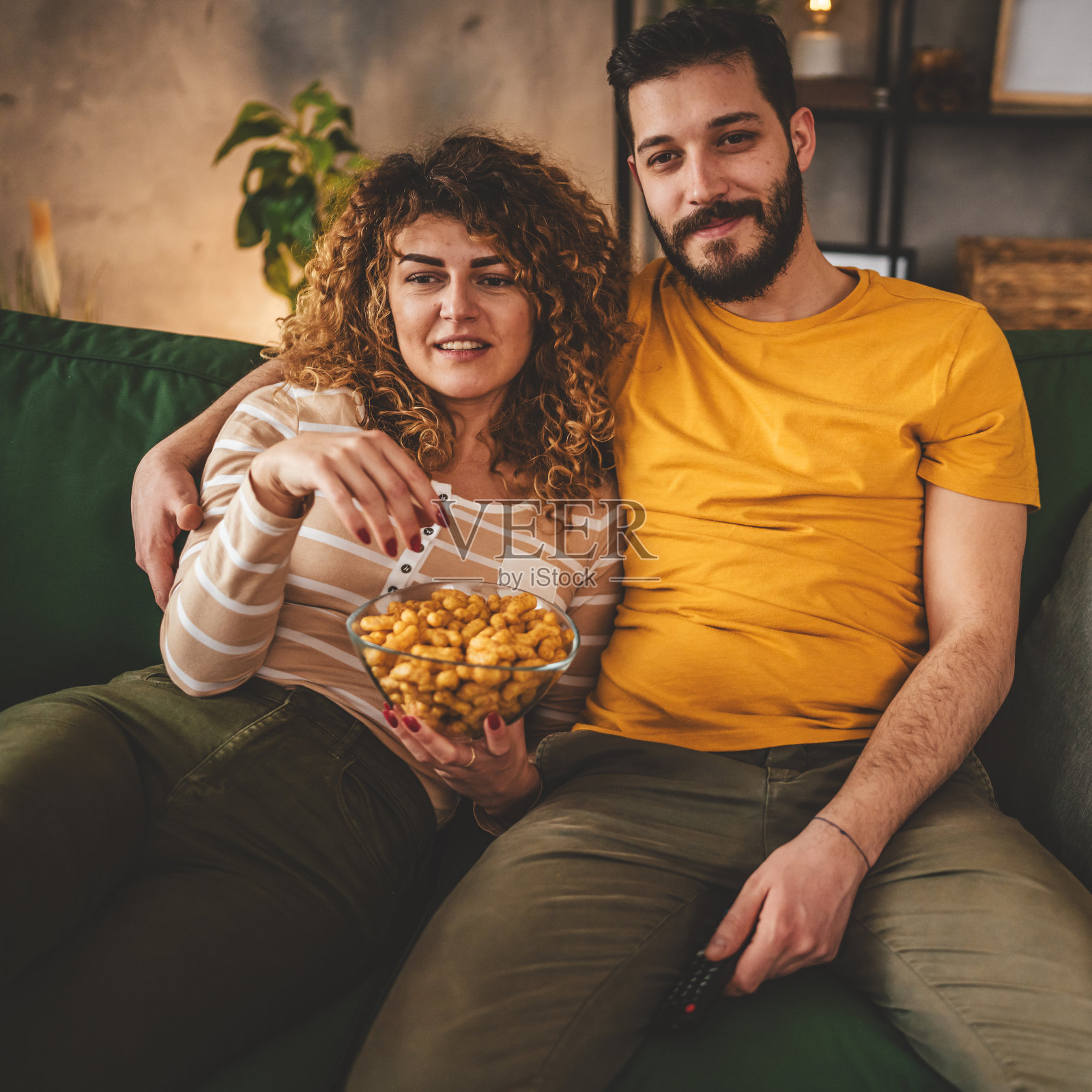 一对白人男女坐在家里的沙发床上看电视电影照片摄影图片