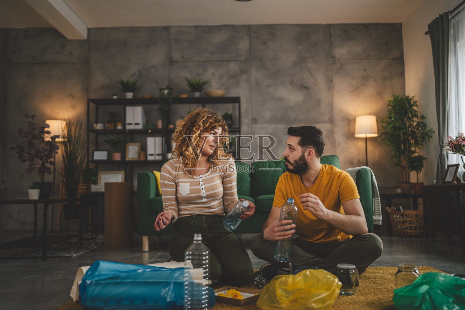 夫妻俩在家里分类回收废旧塑料、废纸和玻璃照片摄影图片