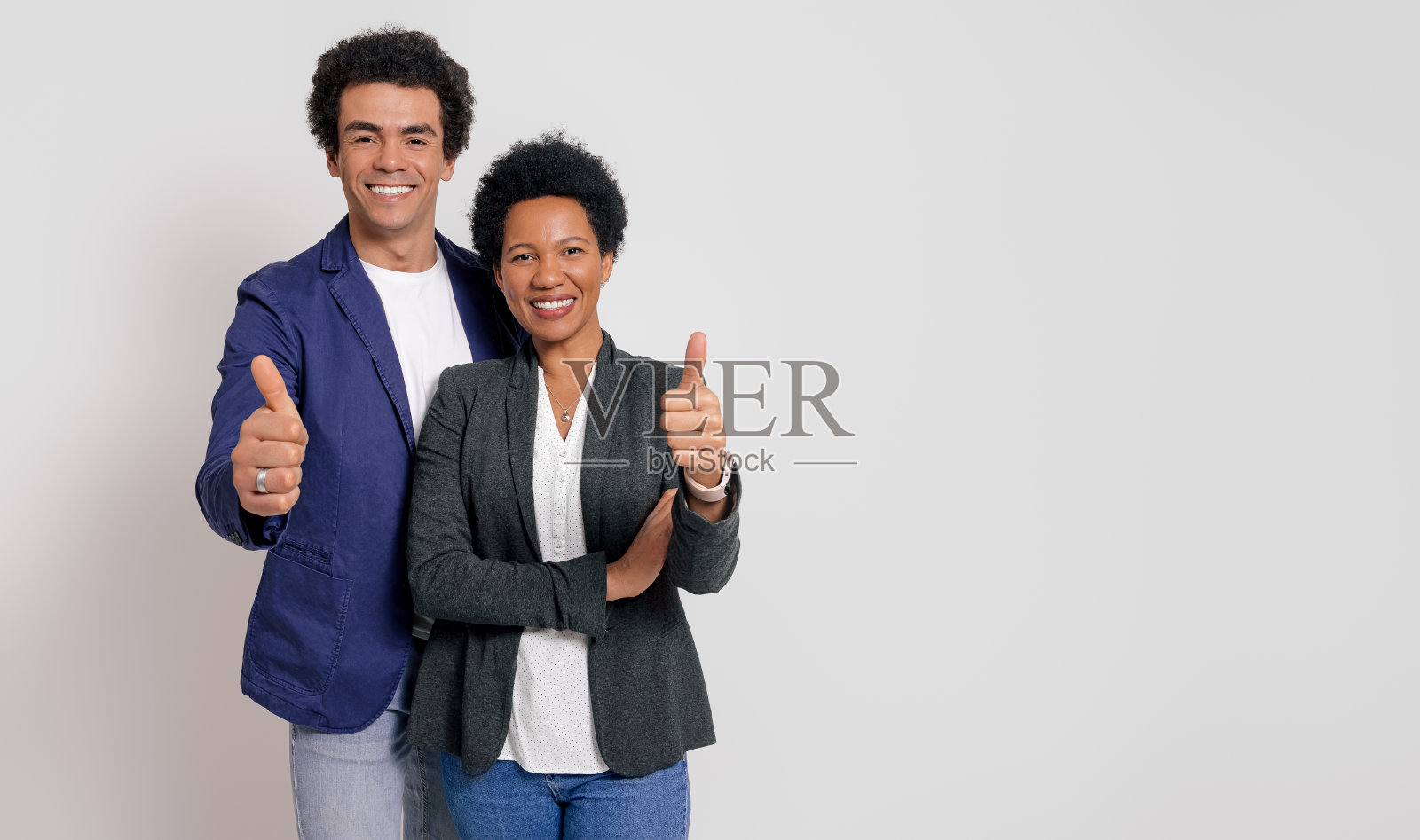 站在白色背景上微笑着竖起大拇指的商业同事的肖像照片摄影图片