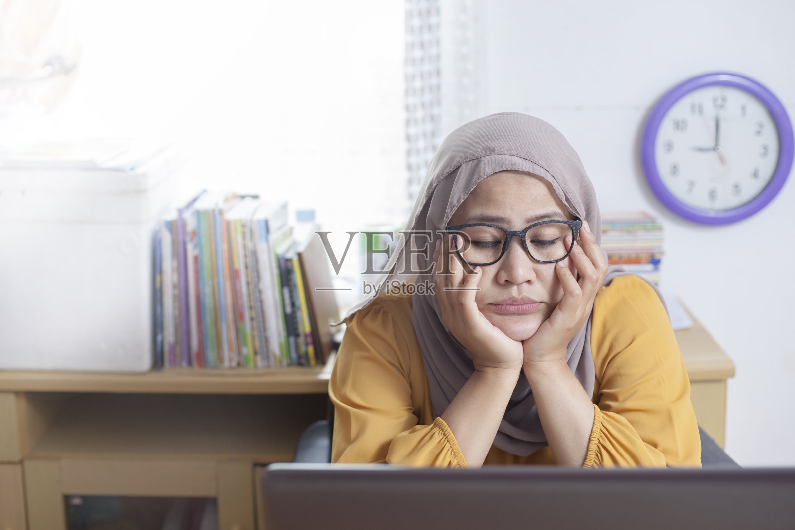 疲惫困倦的穆斯林女商人在笔记本电脑前等待照片摄影图片