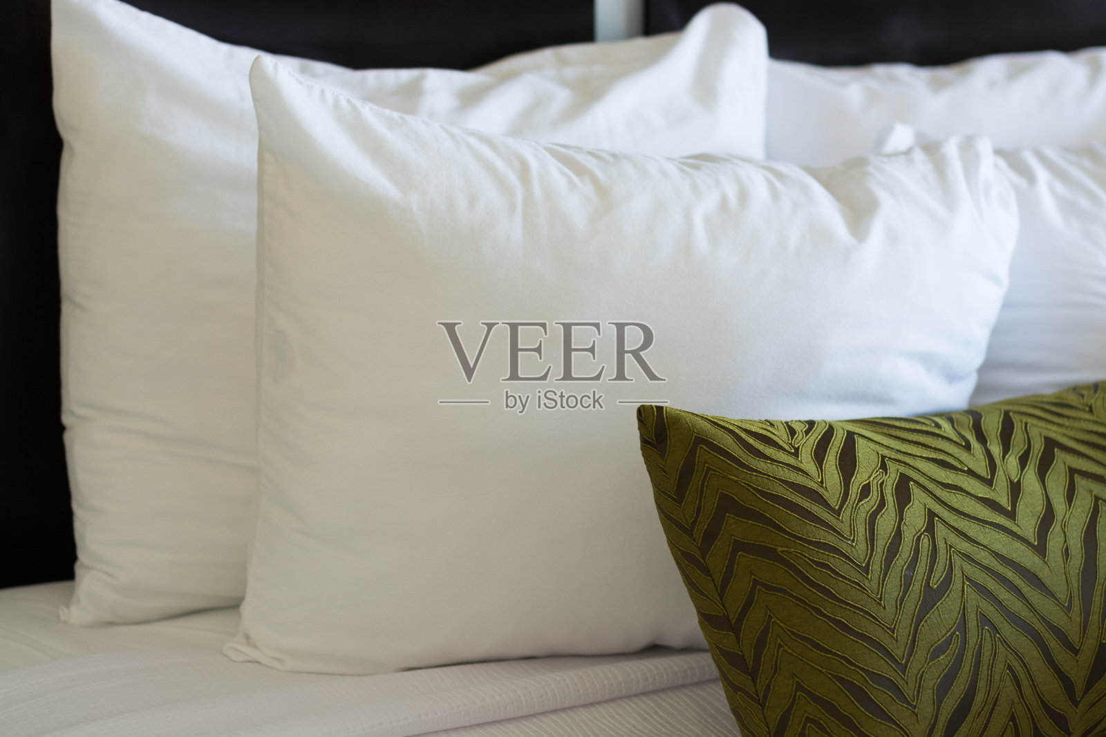 丰富的枕头装饰着一张精美的床。照片摄影图片