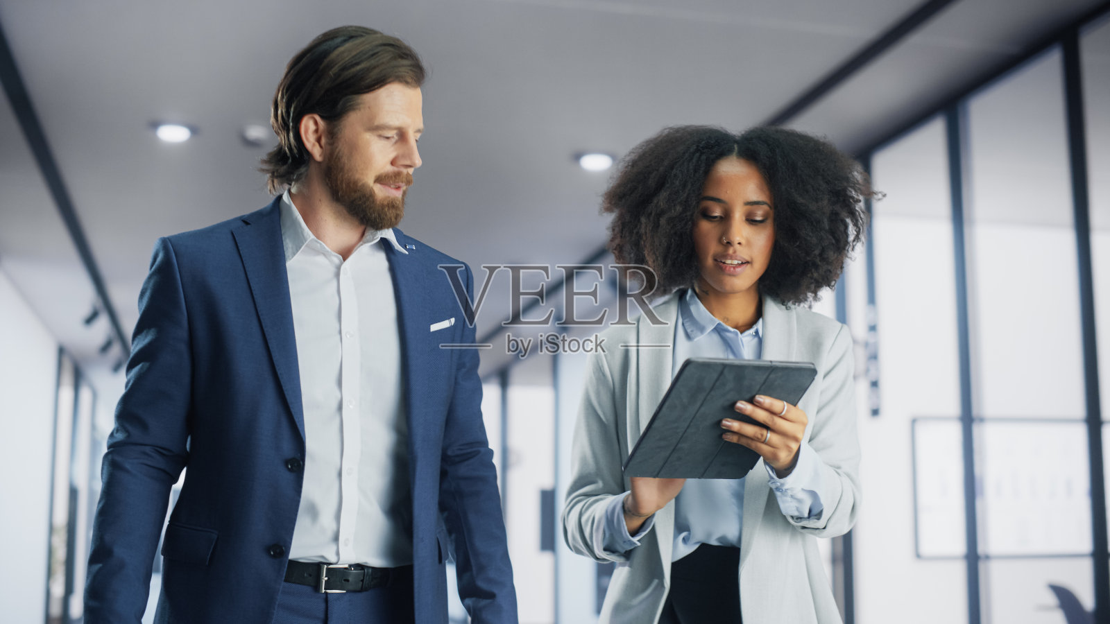 年轻的非洲项目经理与英俊的高加索商人同行。女性与公司CEO讨论商业计划。企业家用平板电脑分享公司动态。照片摄影图片