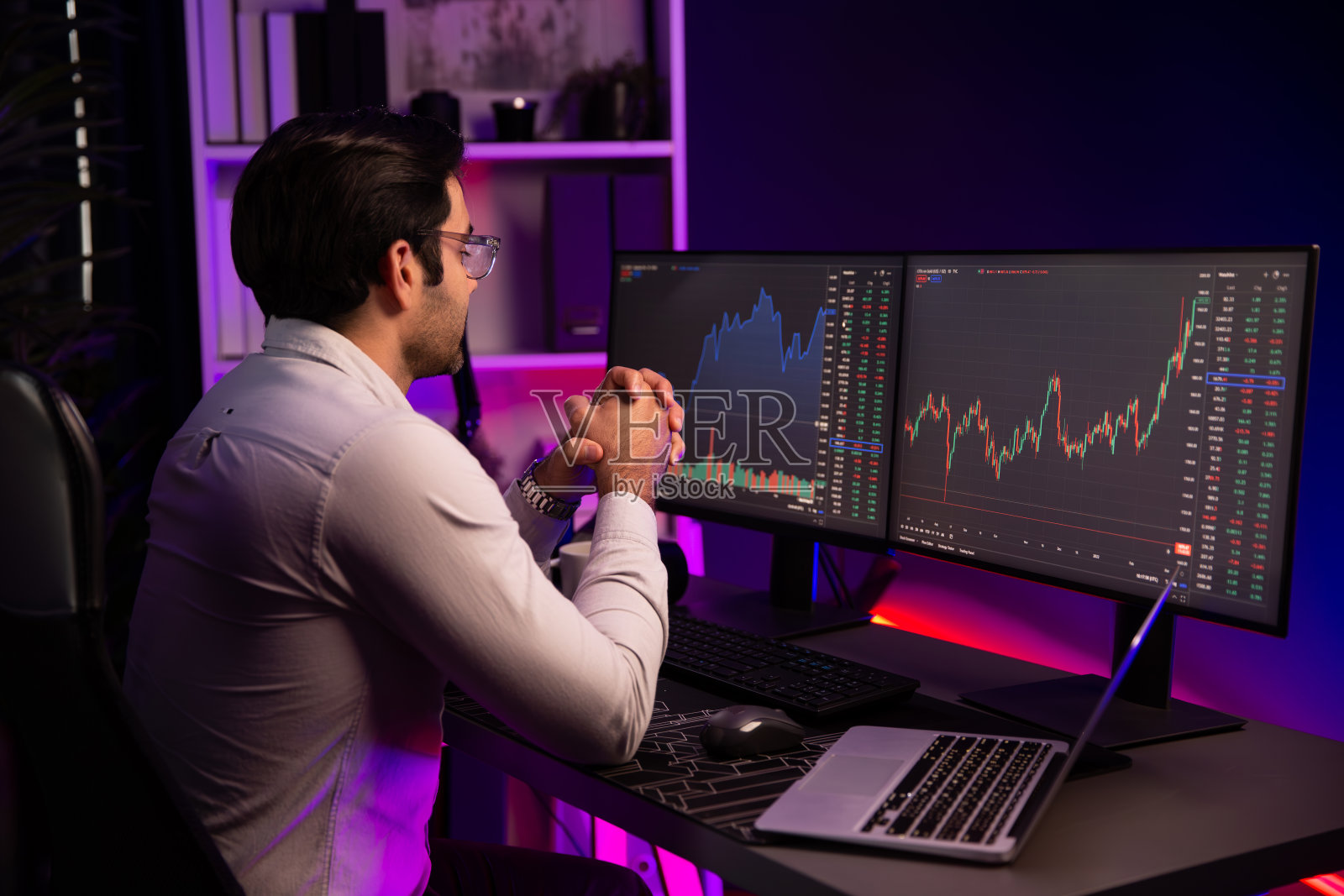 聪明的交易员专注于动态股票交易的个人电脑和笔记本电脑。推测。照片摄影图片