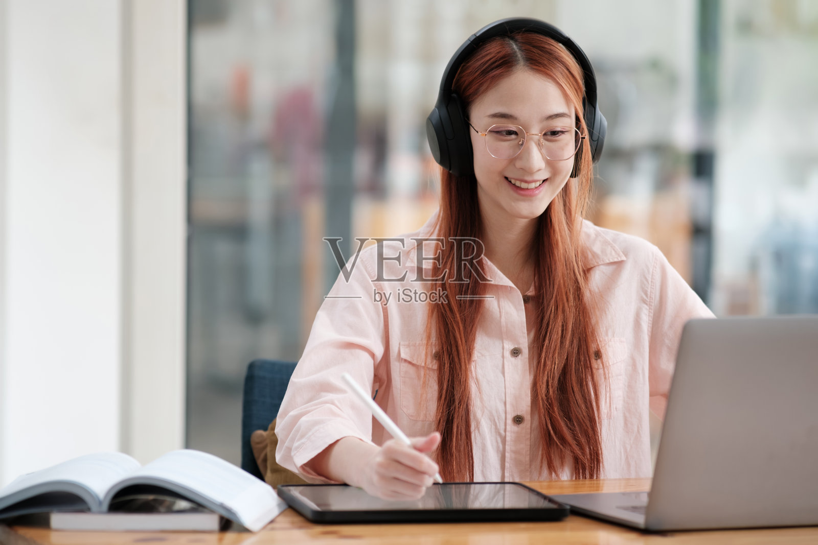 年轻的大学生使用电脑和移动设备在线学习。照片摄影图片