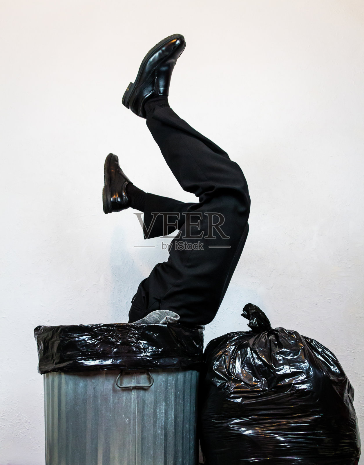 倒立在垃圾桶里的商人照片摄影图片