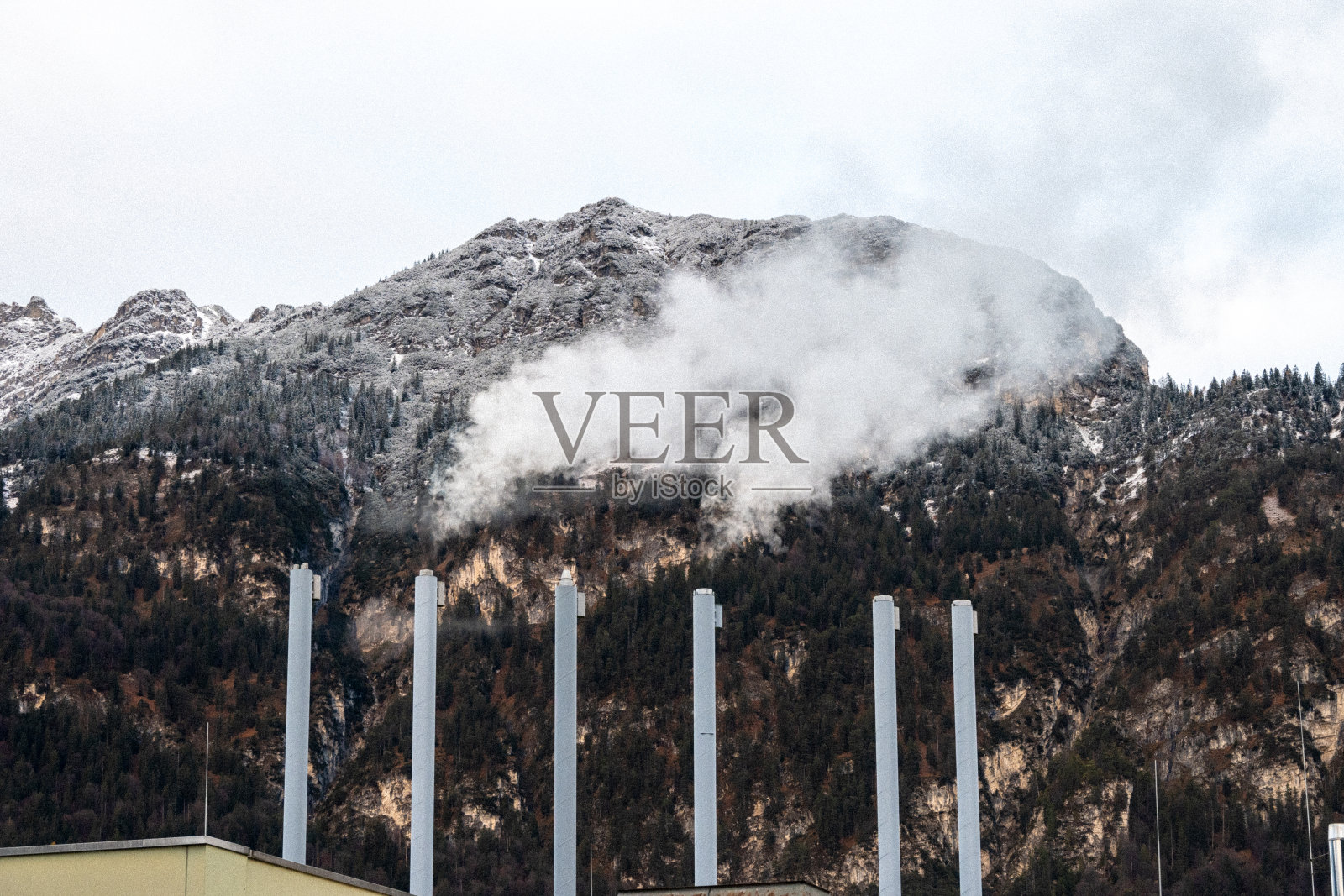 工业烟囱在山的背景下散发蒸汽照片摄影图片