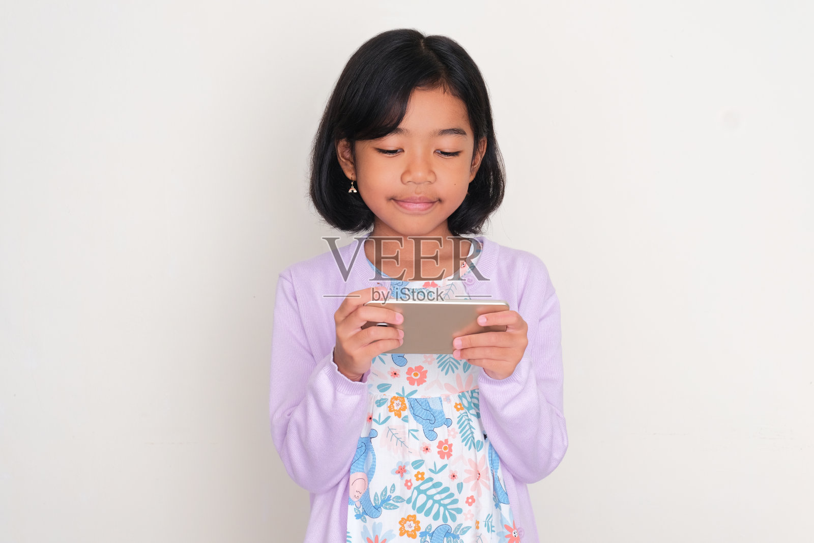 亚洲小孩看手机时微笑照片摄影图片