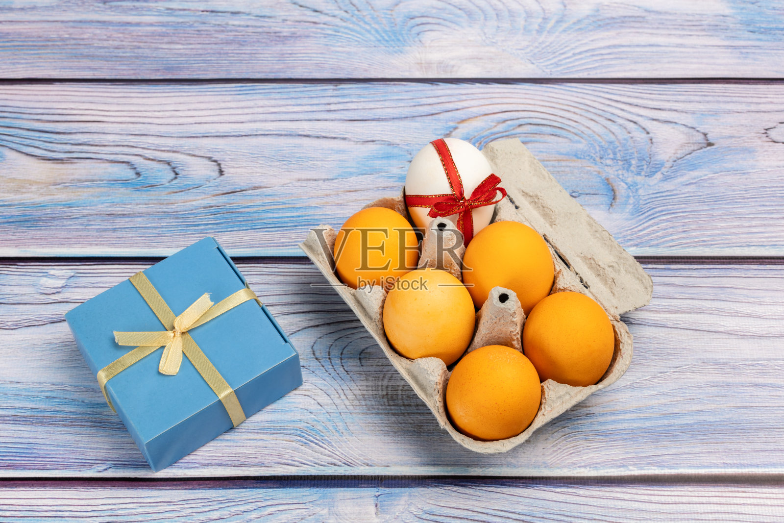 复活节彩蛋在一个盒子和一个礼品盒上的木制背景照片摄影图片