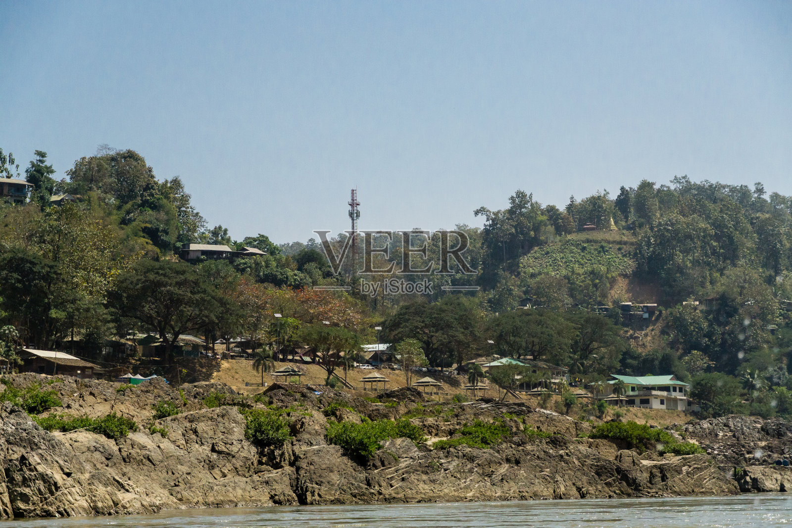 泰国河边山上的一所小房子。照片摄影图片