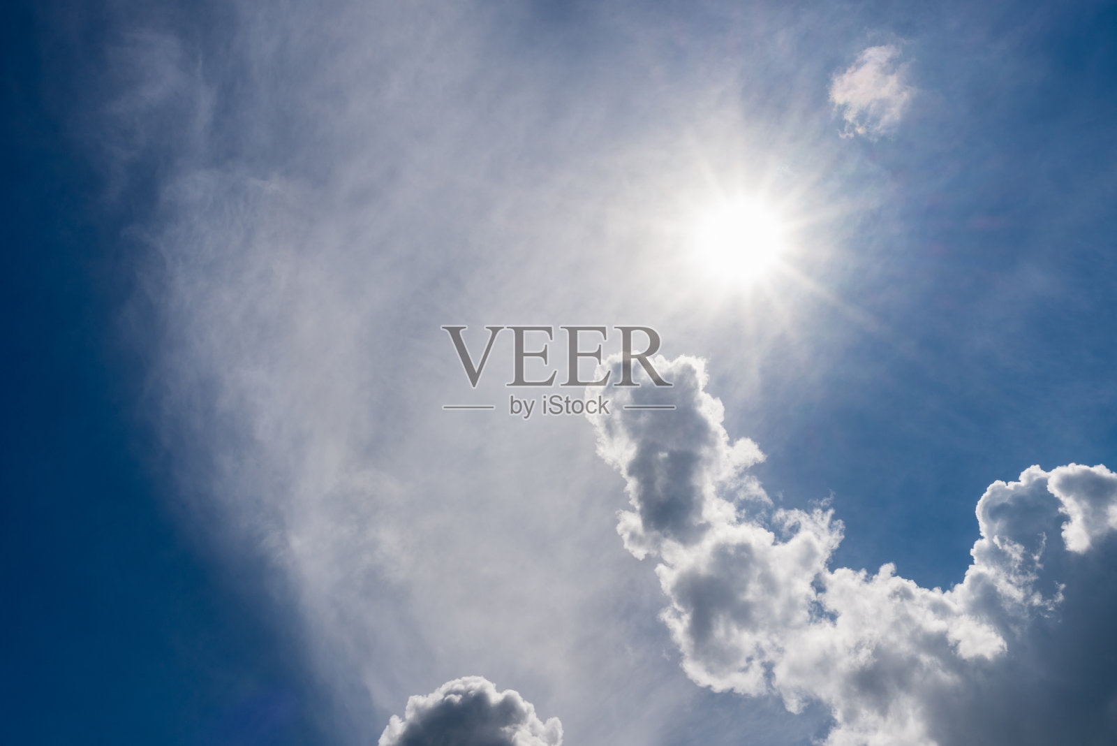 蓝色的天空，阳光透过云层。引人注目的蓝天、云彩和阳光照片摄影图片