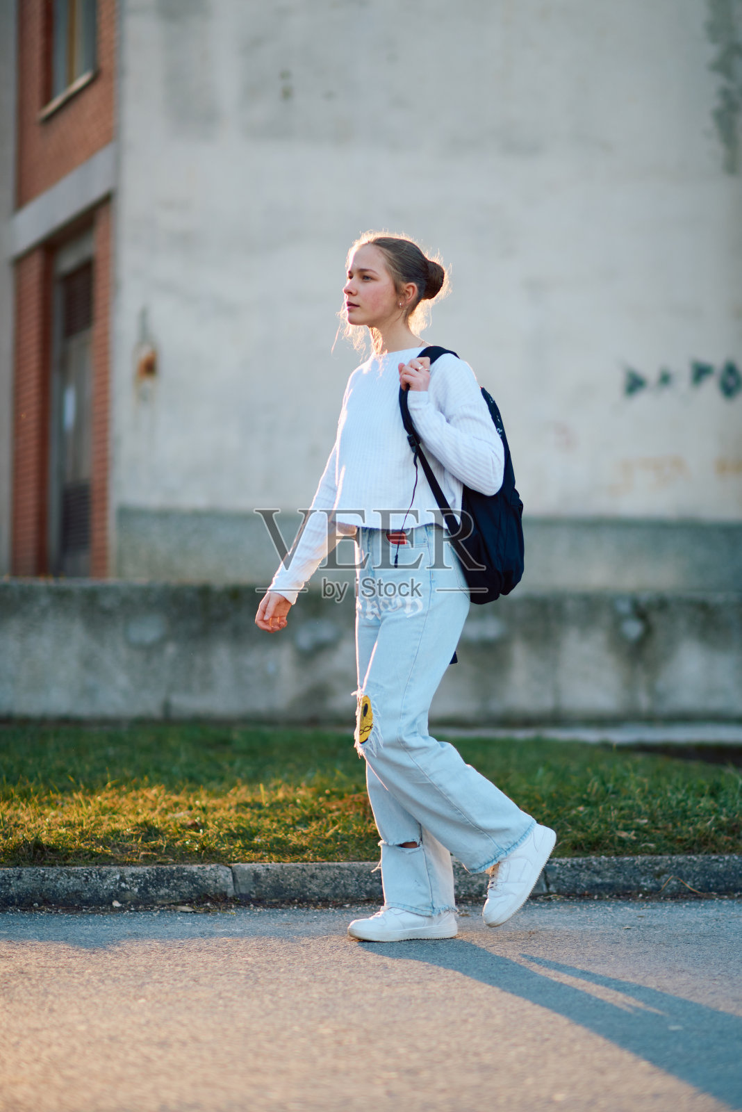 放学后夕阳下背着书包回家的欧洲少女侧写照片摄影图片