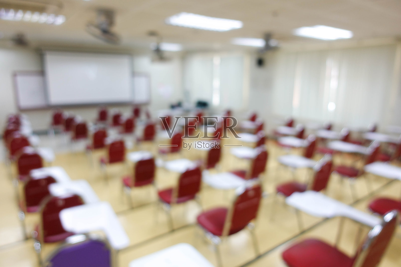 模糊了有本科生的考场的抽象背景。一个学生在考场做期末考试的模糊画面。大学学习椅的模糊视图。照片摄影图片