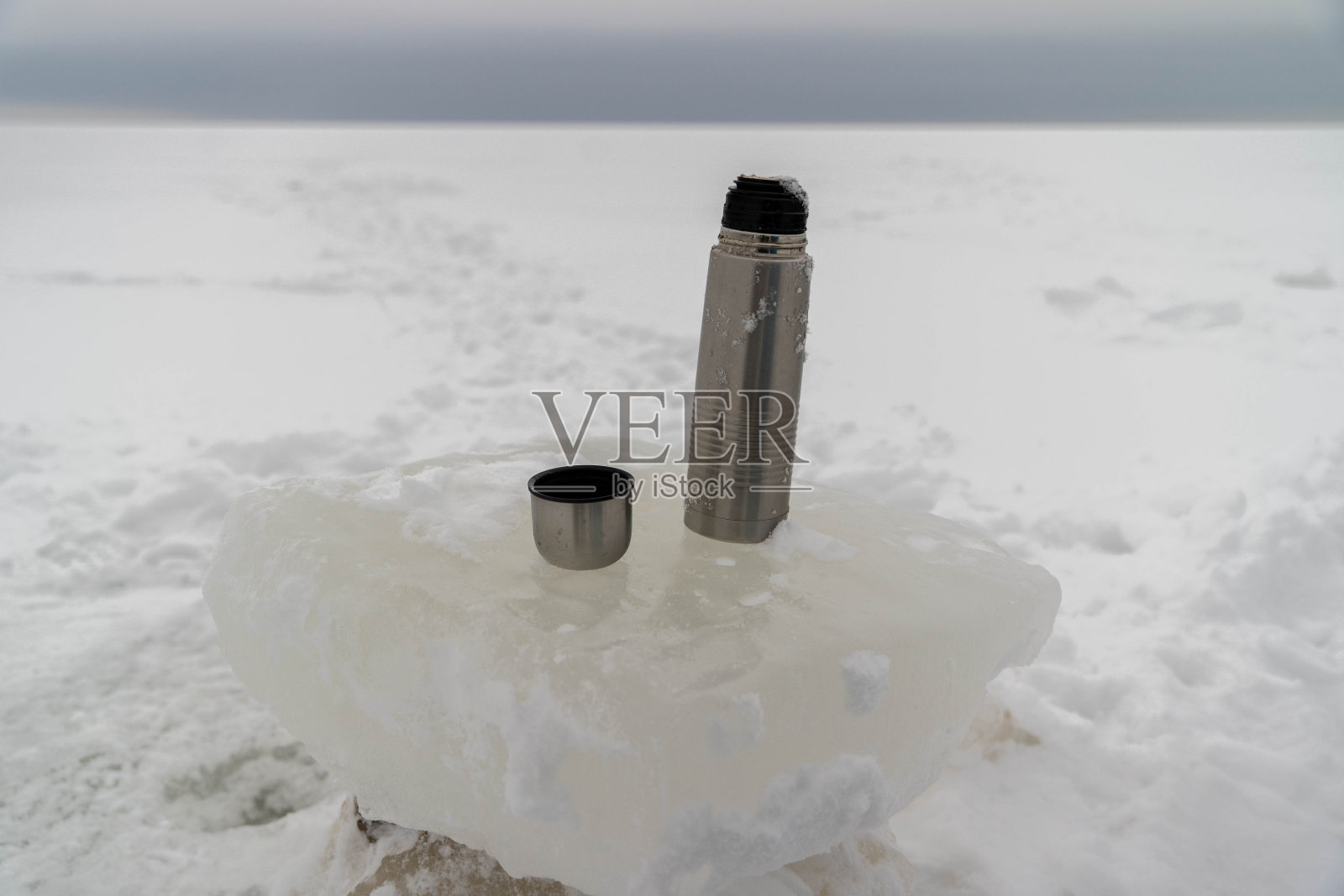 户外旅行理念:小露营保温瓶和冰桌上的热茶照片摄影图片