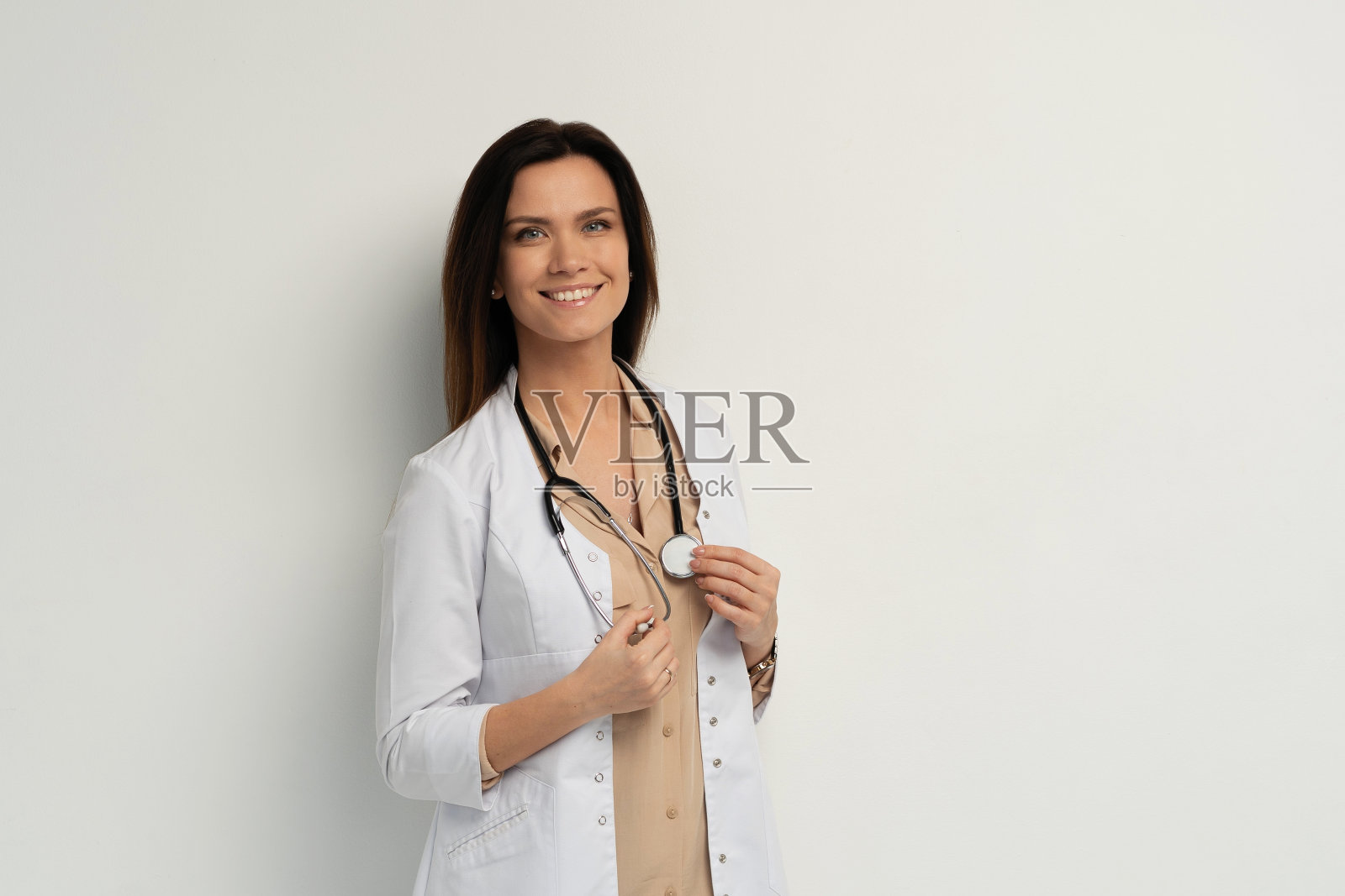 一位穿着白大褂的年轻迷人女医生的画像。照片摄影图片