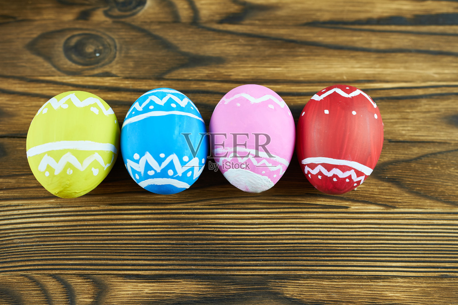 木制背景上五颜六色的复活节彩蛋。复活节快乐的概念。照片摄影图片