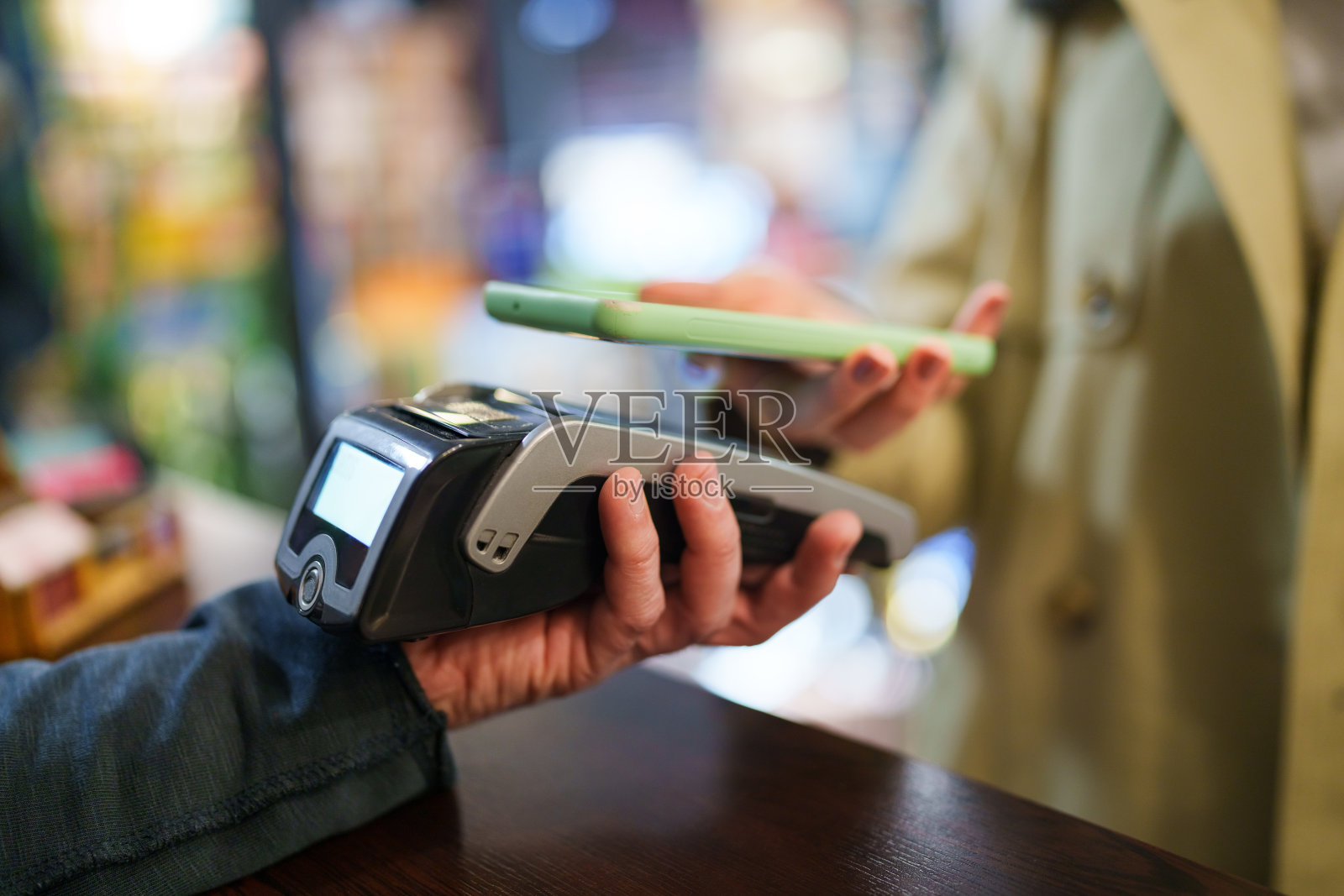 年轻的亚洲女性在书店结账时使用手机支付。照片摄影图片