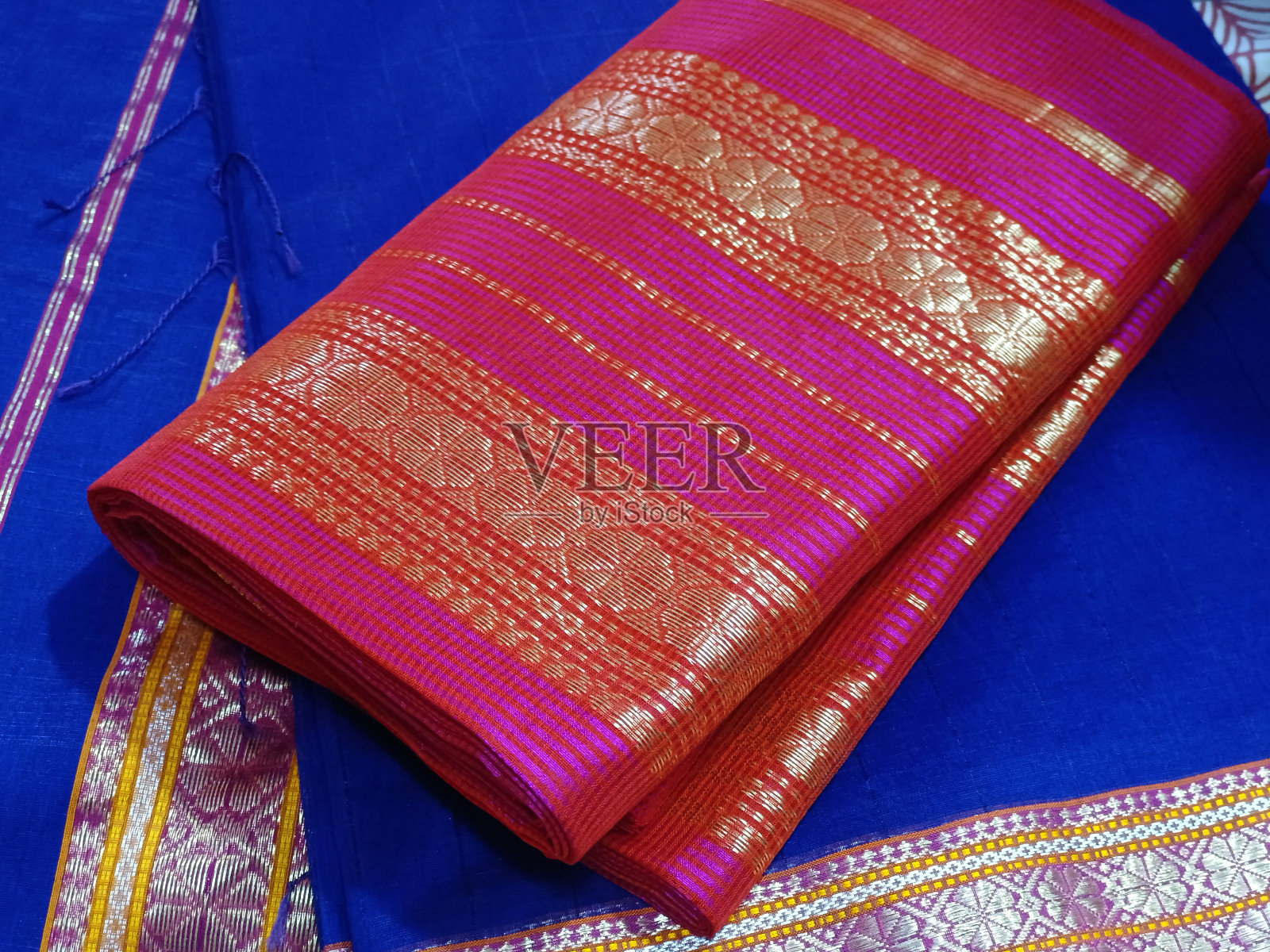 手工编织丝绸和手工织造纱丽，带有金色细节的纱丽，妇女在节日，仪式和婚礼上穿着，昂贵的纱丽以其金银织锦而闻名。令人难以置信的印度。照片摄影图片