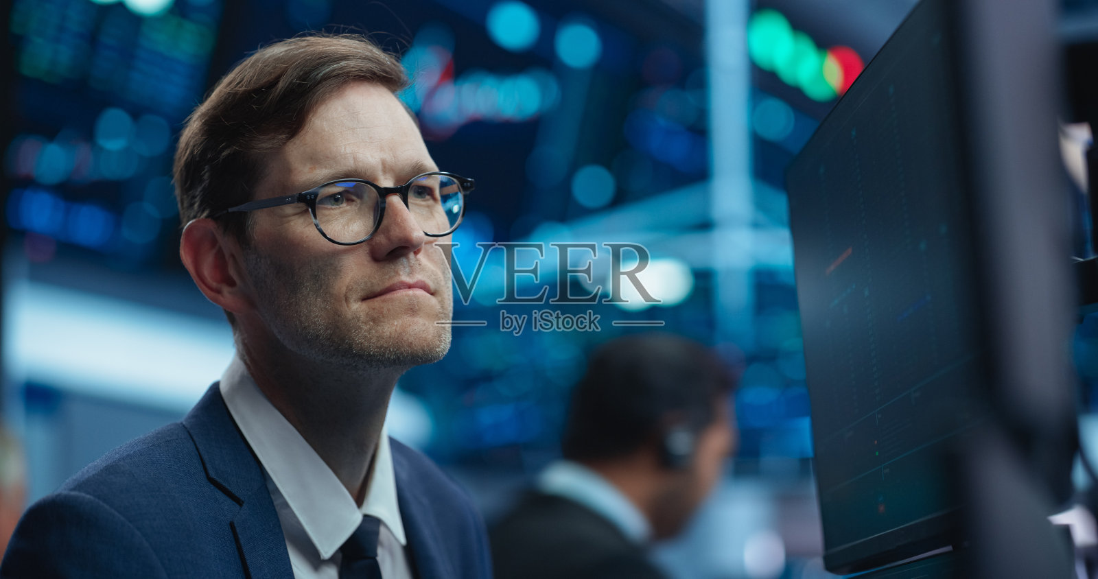 一个在国际证券交易公司工作的成年人的肖像:专业使用多屏幕计算机，监控金融市场，与商业伙伴沟通。照片摄影图片