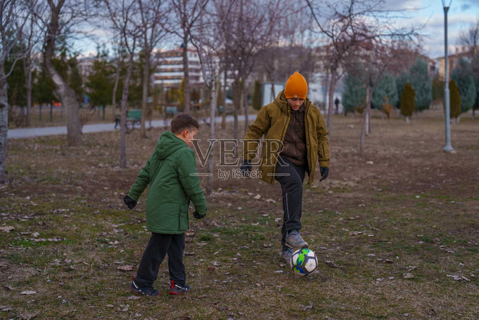 兄弟姐妹在公园里追足球照片摄影图片