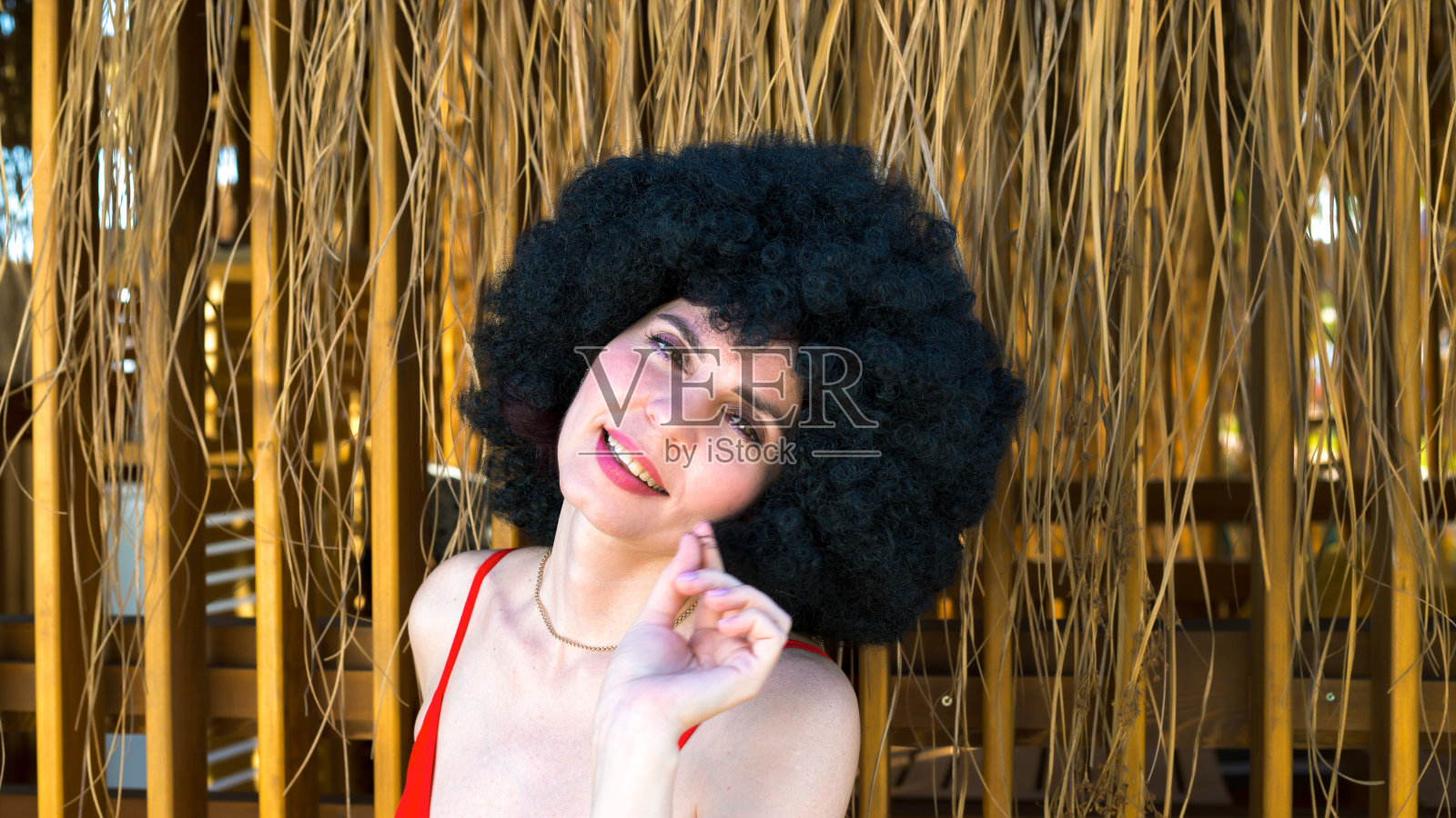 在一个独立的海滨别墅附近为一个黑色卷发的女孩拍照照片摄影图片