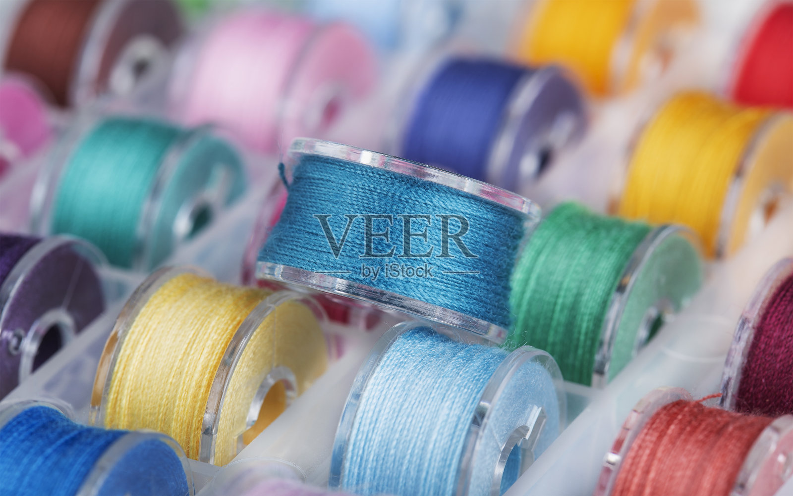 多色线缝纫机用的塑料线轴。照片摄影图片