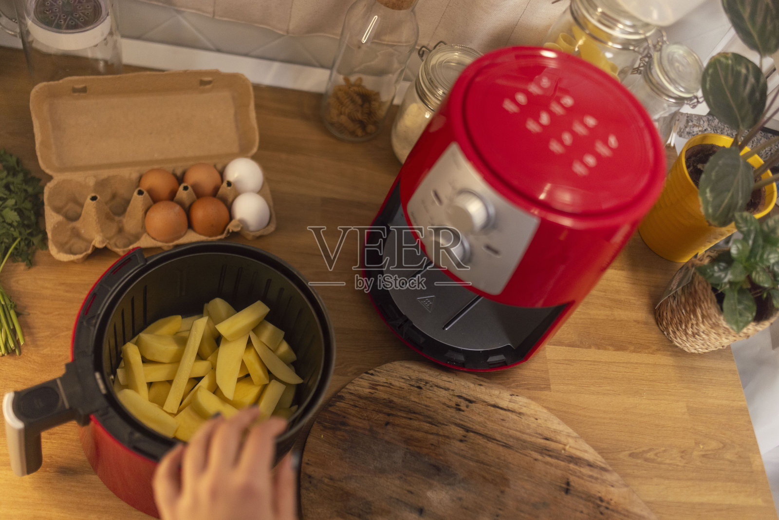 一个面目全非的女人在厨房用空气炸锅准备午餐照片摄影图片