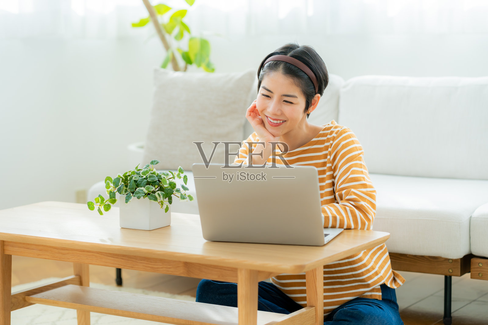 一个年轻的日本女人在客厅放松地看着电脑照片摄影图片