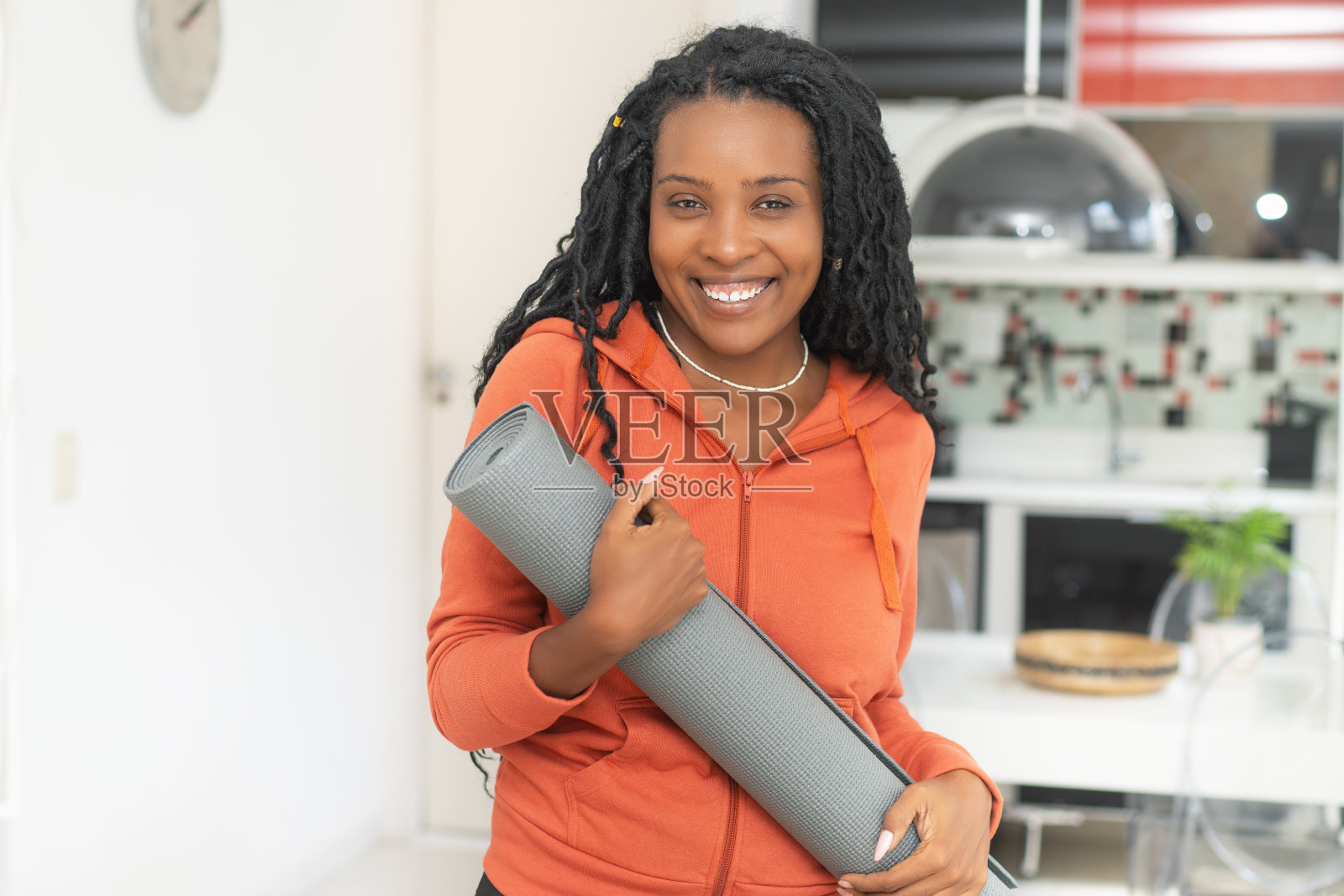 Beautiful black woman with yoga mat ready for class at gym照片摄影图片