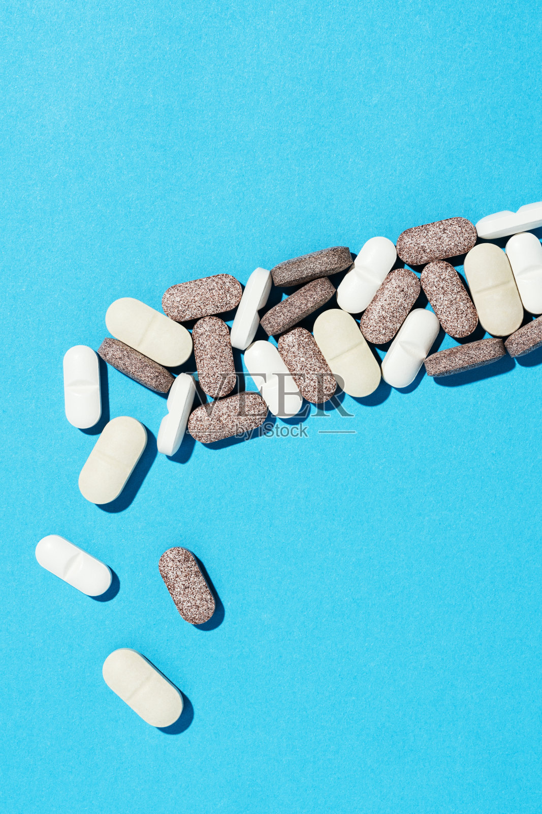白色和棕色药片在蓝色背景照片摄影图片