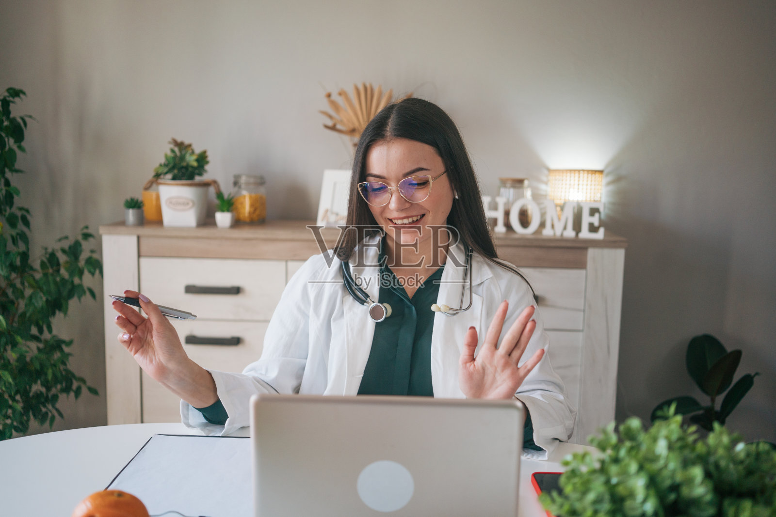 一位年轻的女医生正在用她的笔记本电脑工作。照片摄影图片