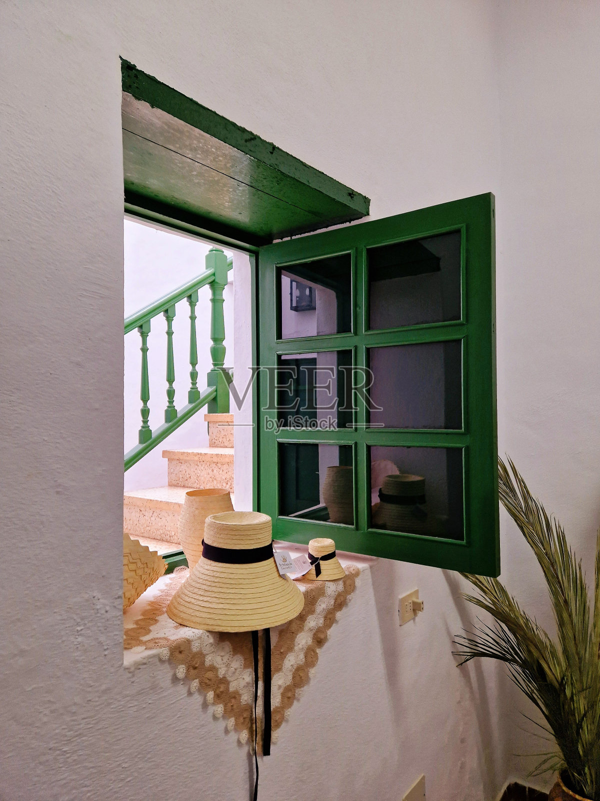 老式加那利农舍天井内院窗台上的传统兰萨罗特草帽——传统白色与绿色的田园、乡村形象照片摄影图片