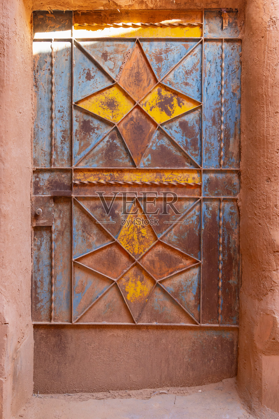 乌沙格遗产村一座旧泥砖建筑上的彩绘金属门。照片摄影图片
